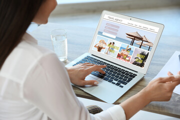 Woman using laptop to plan trip, closeup. Travel agency website - obrazy, fototapety, plakaty