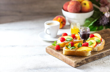 Summer snack - sandwiches with cream cheese and fresh peaches on a light concrete background. Homemade Summer Breakfast.