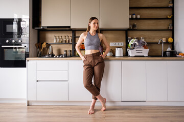 Morning atmosphere in a modern kitchen. Beautiful woman stands posing and relaxing. Modern woman...