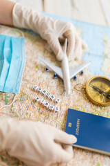 Obraz premium Corona virus pandemic in travel industry. travel agency working table. map, toy plane, compass, face mask and trip planning after quarantine restrictions due to epidemic covid corona virus. Tourism 