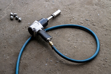 Pneumatic wrench or backyard mechanics impact wrench for replacement tires is laying on the ground.