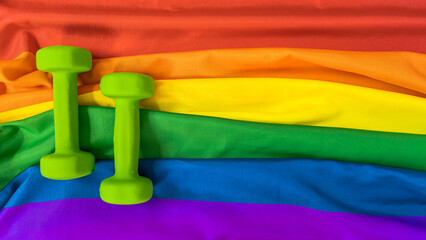 Dumbbells sports on the rainbow flag LGBT flag for design. The concept of sports and a healthy lifestyle in the LGBT community.