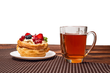 Home made cake with cream and fruits and tea isolated on white.