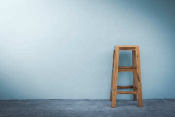 The background of the blue wall and wooden chair.