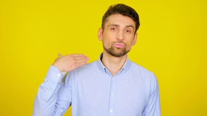 I'm fed up with this. Displeased bearded man in a light blue shirt with hand near the neck on a...