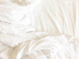 Unmade bed; wrinkled pillowcases, bed sheet and duvet