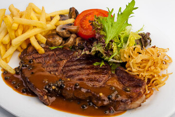 Gravy meat with french fries, mushrooms and tomato