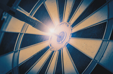 Close up shot of the dart arrow hit on bull eyes of dartboard to represent that the business reached the target of company with Monochrome tone picture style. target and goal ass concept.