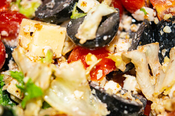 Vegetable salad with cheese. Fitness salad with tomatoes, onions, olives, lettuce and cheese. Surface texture. Close up.