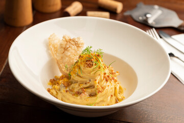Carbonara pasta on white plate with a blurred background