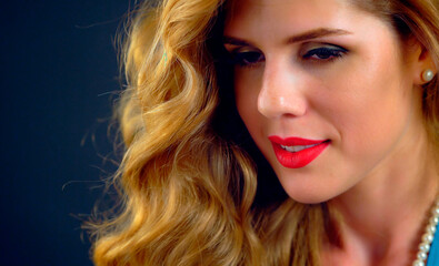 Studio authentic portrait woman with blonde long curly hair.