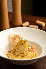 Carbonara pasta on white plate with a blurred background