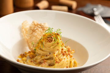 Carbonara pasta on white plate with a blurred background