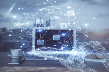 Desktop computer background in office and flying envelops hologram drawing. Multi exposure. Electronic mail concept.