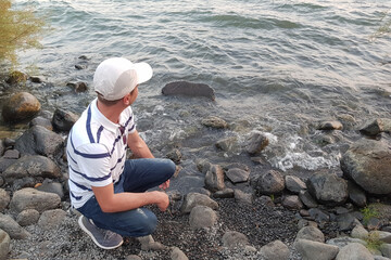 guy looks into the distance at the lake and dream