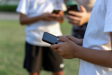 Shot of unrecognizable people using mobile phone outside.Selective focus of group of young people using their mobile phones together.Close up image of couple of friends using phones together outdoors.