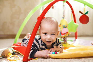Cute  baby is playing on the activity mat