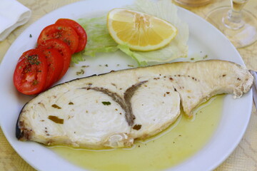 Grilled swordfish with tomatos and limon - traditional dish in local taverna in Calabria, Italy