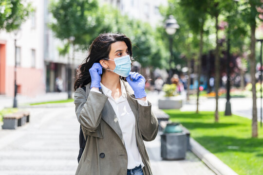 Girl in respiratory mask. Cold, flu, virus, tonsillitis, respiratory disease, quarantine, epidemic concept. Young woman on the street wearing face protective mask to prevent Coronavirus and anti-smog