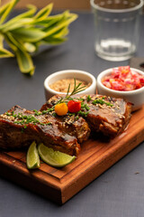 Ribs on barbecue on a wooden board with a blurred background