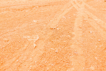 Wheel tracks in extremely dry light brown dusty clay soil as texture