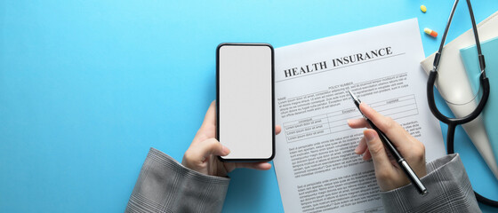 Female fill out insurance form while looking information on mock-up smartphone