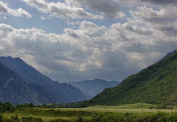 Altai mountains near the Katun river on a background of clouds. Green mountains and valley. Altai. Siberia.