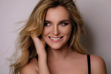 Naklejka premium Gorgeous woman with a beautiful curly hair and professional makeup