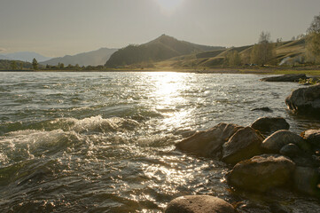 The stormy water of the Katun river at sunset. Green mountains and valley. Altai. Siberia.