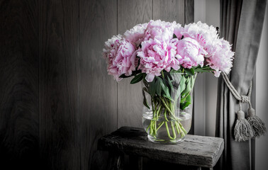 Pink peonies in vase on rustic wooden table. Romantic home decoration. © Nancy Pauwels