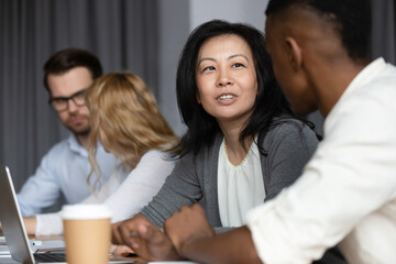 Focus to asian ethnicity middle-aged woman mentor more experienced worker teach African guy...