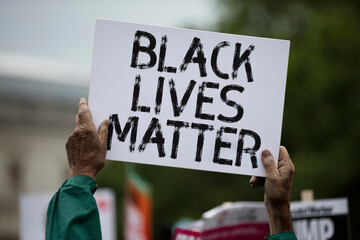 A person holding a black lives matter banner at a protest - obrazy, fototapety, plakaty