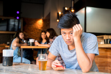 Sad handsome asian man alone in a bar