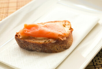 delicious canapes of salted, smoked salmon fillet on slice of fresh ciabatta bread