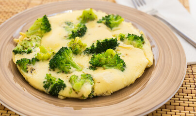 wholesome breakfast. omelet with broccoli on brown plate