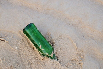Bottles of beer on the beach, trash on the beach.