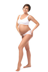 Fototapeta premium Young and beautiful pregnant woman on white background