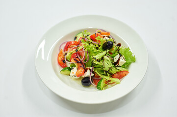 A bowl of salad on a white plate