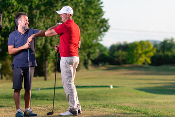 two golfers greet each other by touching their elbows -  golf in the time of the coronavirus