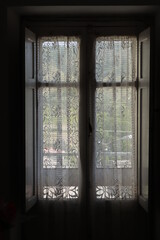 Old Wooden closed Window with a white Curtain