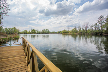 Fototapeta na wymiar Beautiful lake with a bridge with a view over the lake and trees