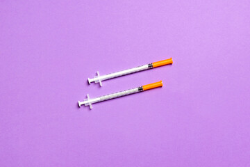 Top view of two insulin syringe at colorful background with copy space. High level of glucose concept