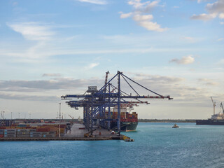 Naklejka premium The Container Terminal at Freeport in the Bahamas, with a Container shipped berthed alongside on one early November Morning.