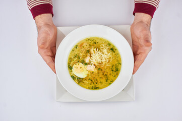 A person holding a bowl of soup