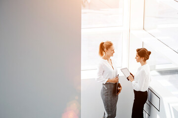  Two female confident leaders having conversation about their successful joint project