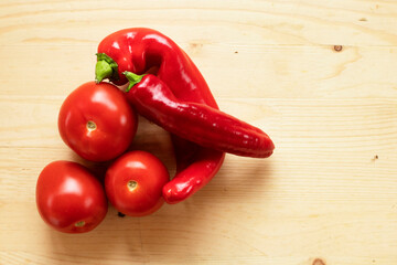 red tomatoes and peppers on a wooden background