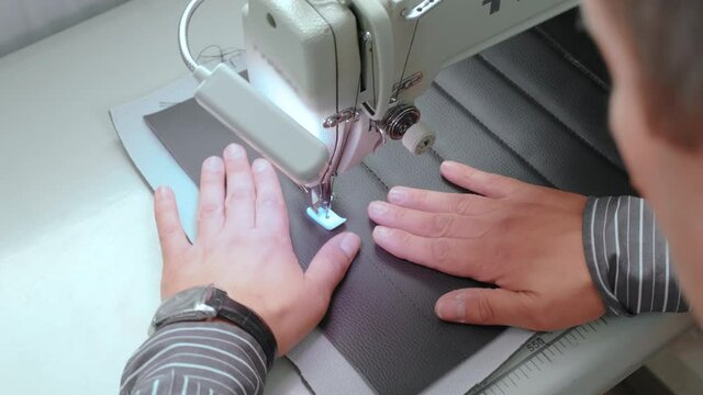 Sewing Process , man sews on a sewing machine