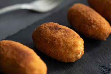 Croquetas de pollo sobre fondo negro