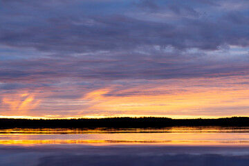 Water surface. Sunset sky background. Gold sunset sky with evening sky clouds over the lake. Small waves. Water reflection