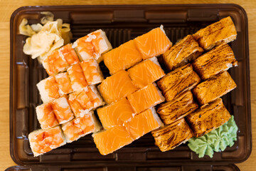 Sushi Roll Delivery. Salmon, eel, tuna, avocado, royal prawn, cream cheese Philadelphia, caviar tobica, chuka, sea cabbage shrimps on wood background